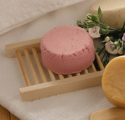 Bath essentials tray with pink bath sponge, wooden brush base, and soap
