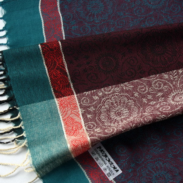 Pashmina shawl corner close-up, teal and burgundy with red stripe and fringe.