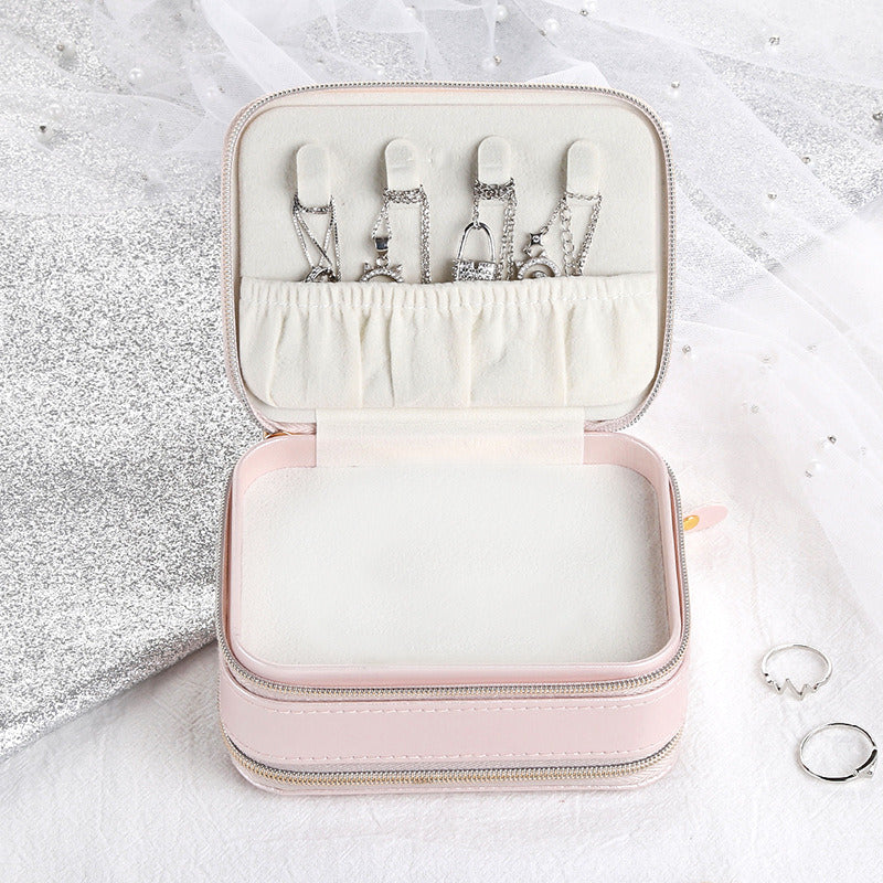 Pink small jewelry case with open lid, ring slots, and inner storage compartments