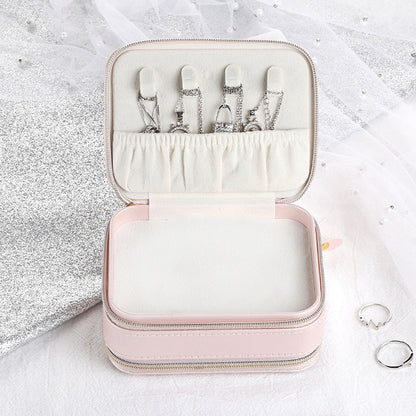 Pink small jewelry case with open lid, ring slots, and inner storage compartments