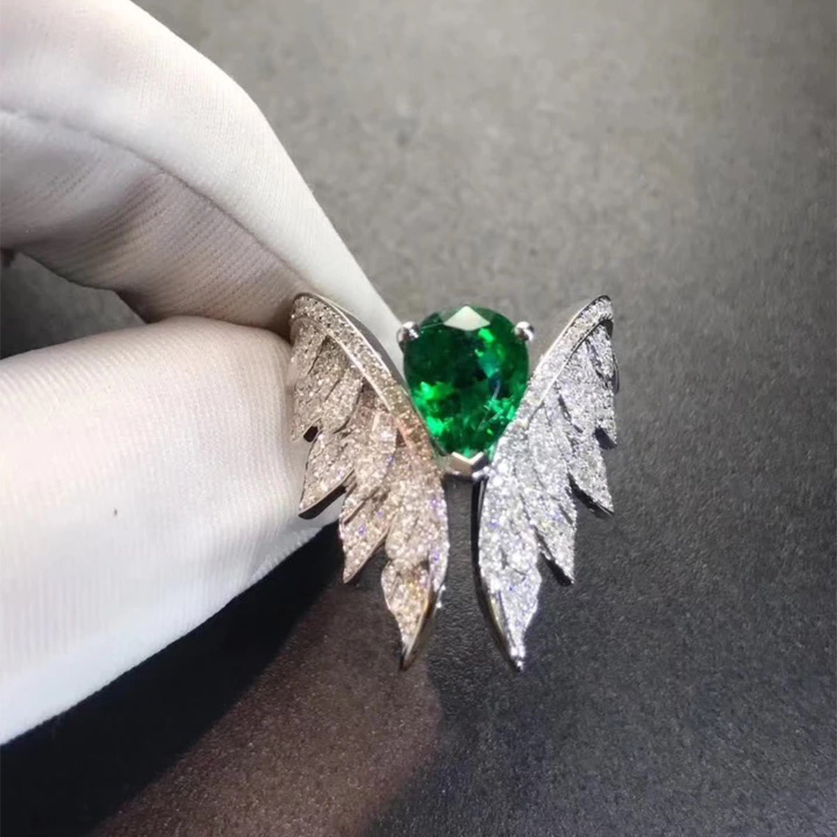 Green teardrop center stone wing zircon cluster ring close-up