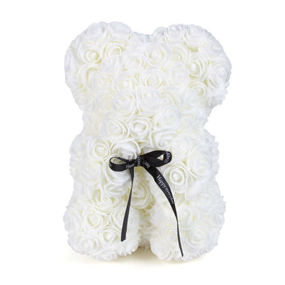White rose teddy bear covered in rosette flowers, with black ribbon bow
