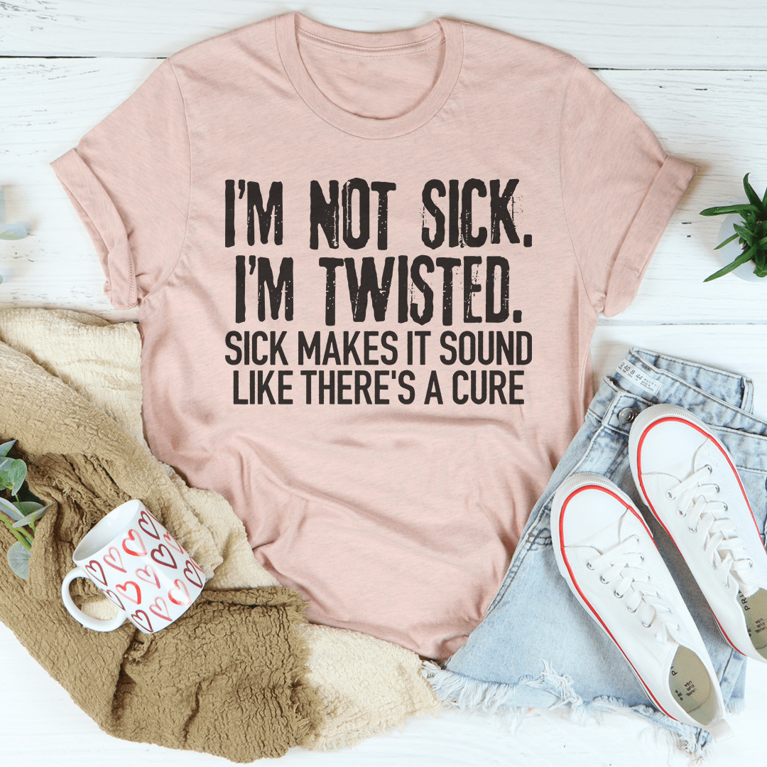 Blush mauve crew-neck T-shirt with bold quote graphic: "I'm Not Sick" "I'm Twisted"
