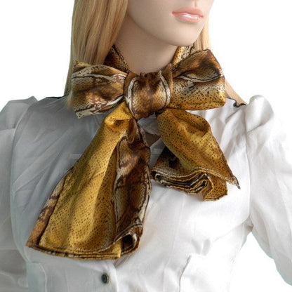 Golden brown snake-print scarf tied in a bow at the neck over a white blouse