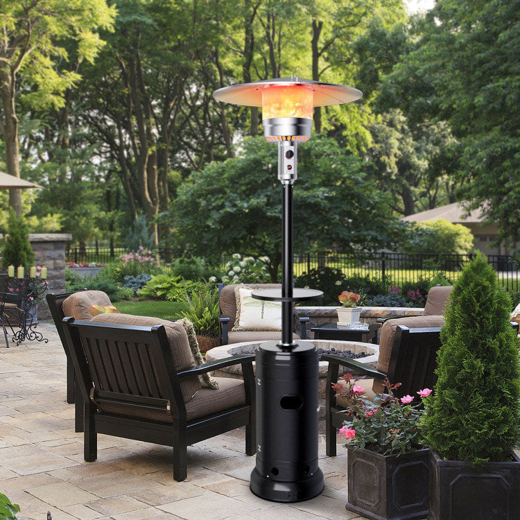 Black propane patio heater standing near seating set and garden plants