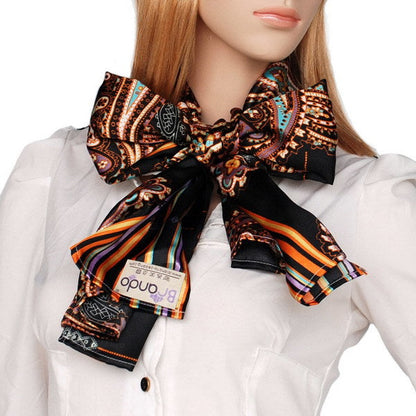 Large silk scarf tied at neck, dark paisley and stripe print with orange and purple accents