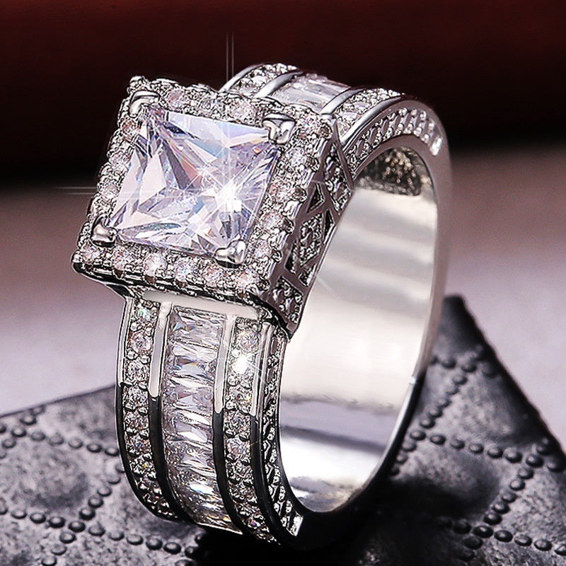 Square-cut halo zircon ring side view with pavé band and silver-toned metal setting
