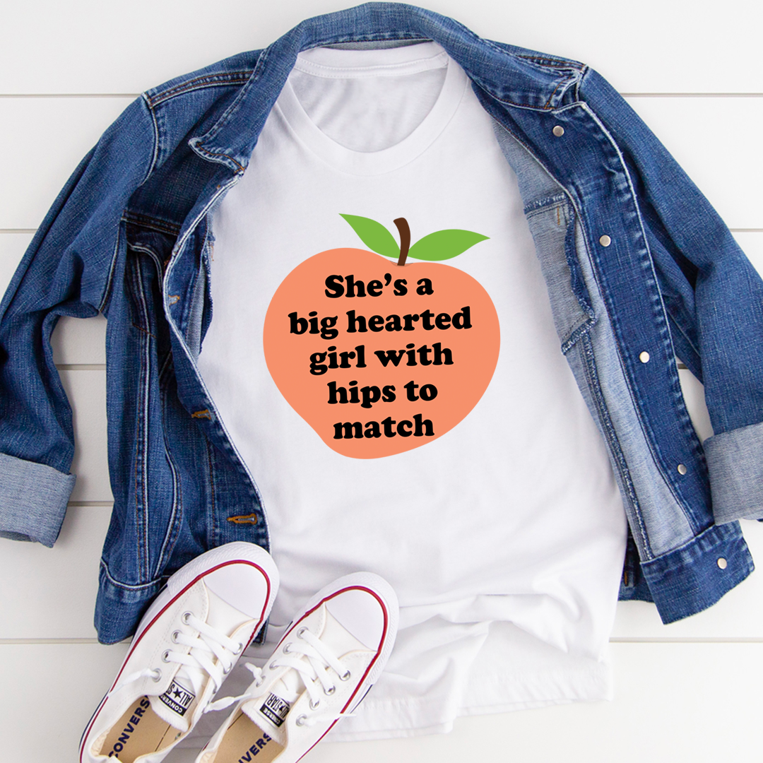White graphic t-shirt with orange heart logo and green leaves; “hips to match” text.