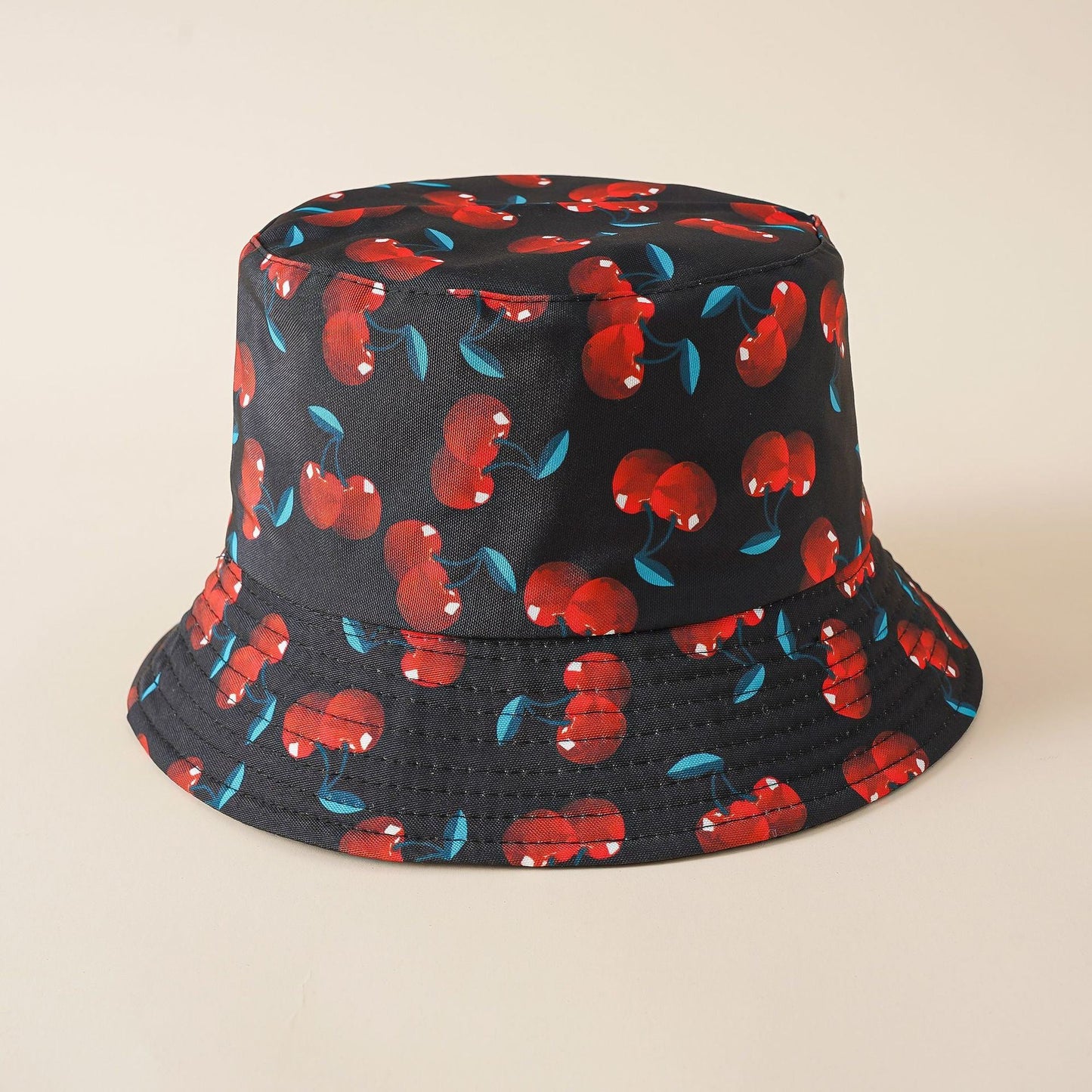 Double-sided cherry bucket hat, dark with red cherry pattern and teal-blue leaf accents