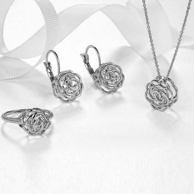 White gold jewelry set with rose-shaped earrings, ring, and pendant necklace
