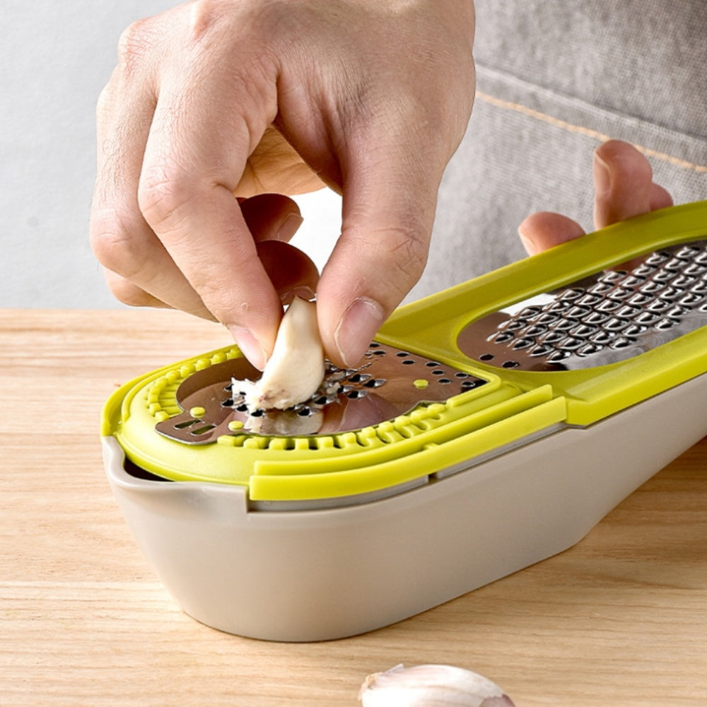 Green citrus juicer grater with cone reamer; hand pressing a garlic clove
