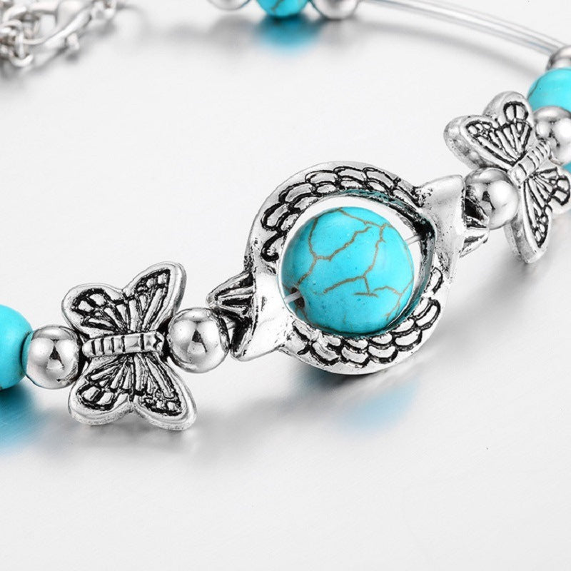 Silver-tone bracelet centerpiece with turquoise cracked resin bead and butterfly charms