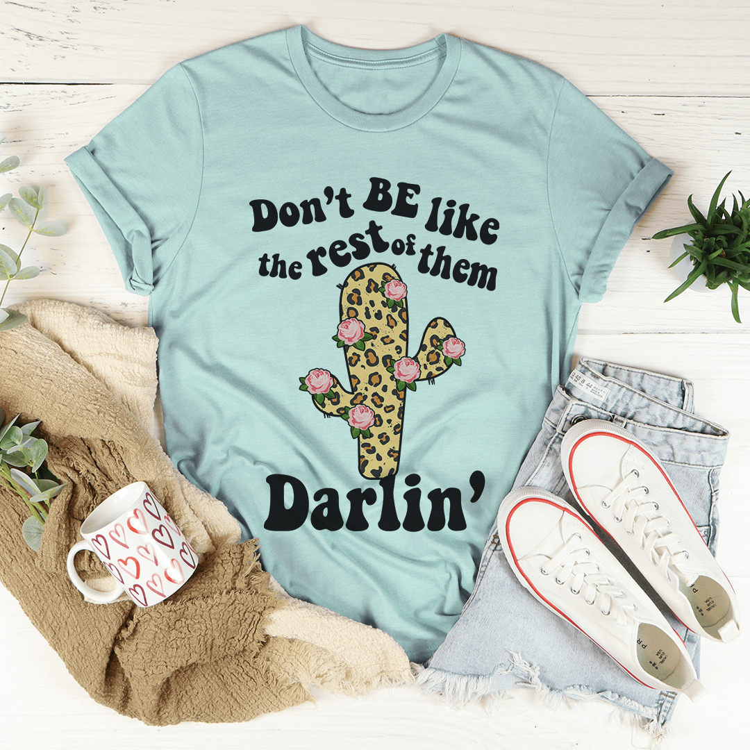Turquoise short-sleeve T-shirt with cactus, flowers, and 'Don't BE like...' text