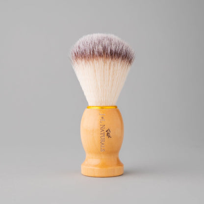 Shave brush with soft gray-and-white bristles and light wood handle
