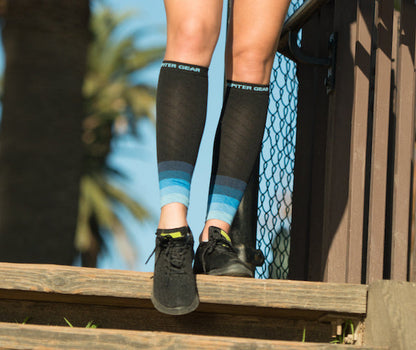 Black compression calf sleeves with light blue stripes and logo band on cuff