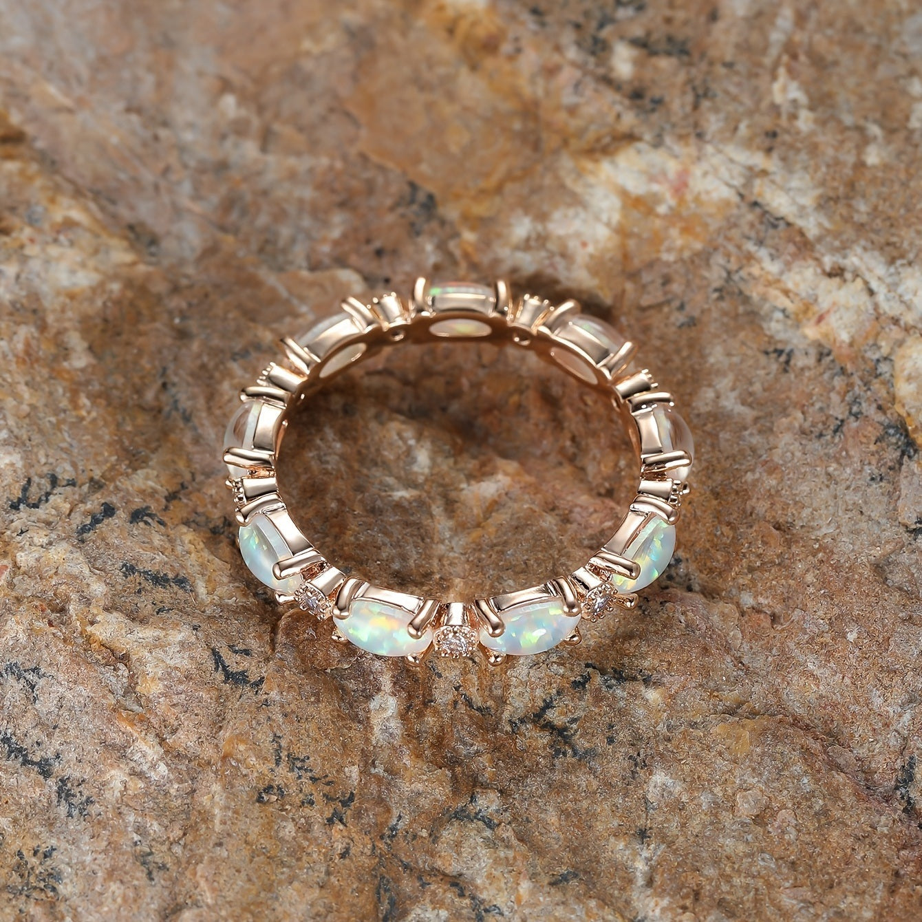 Gold-tone opal bezel ring with round opal stones and small clear accents on band