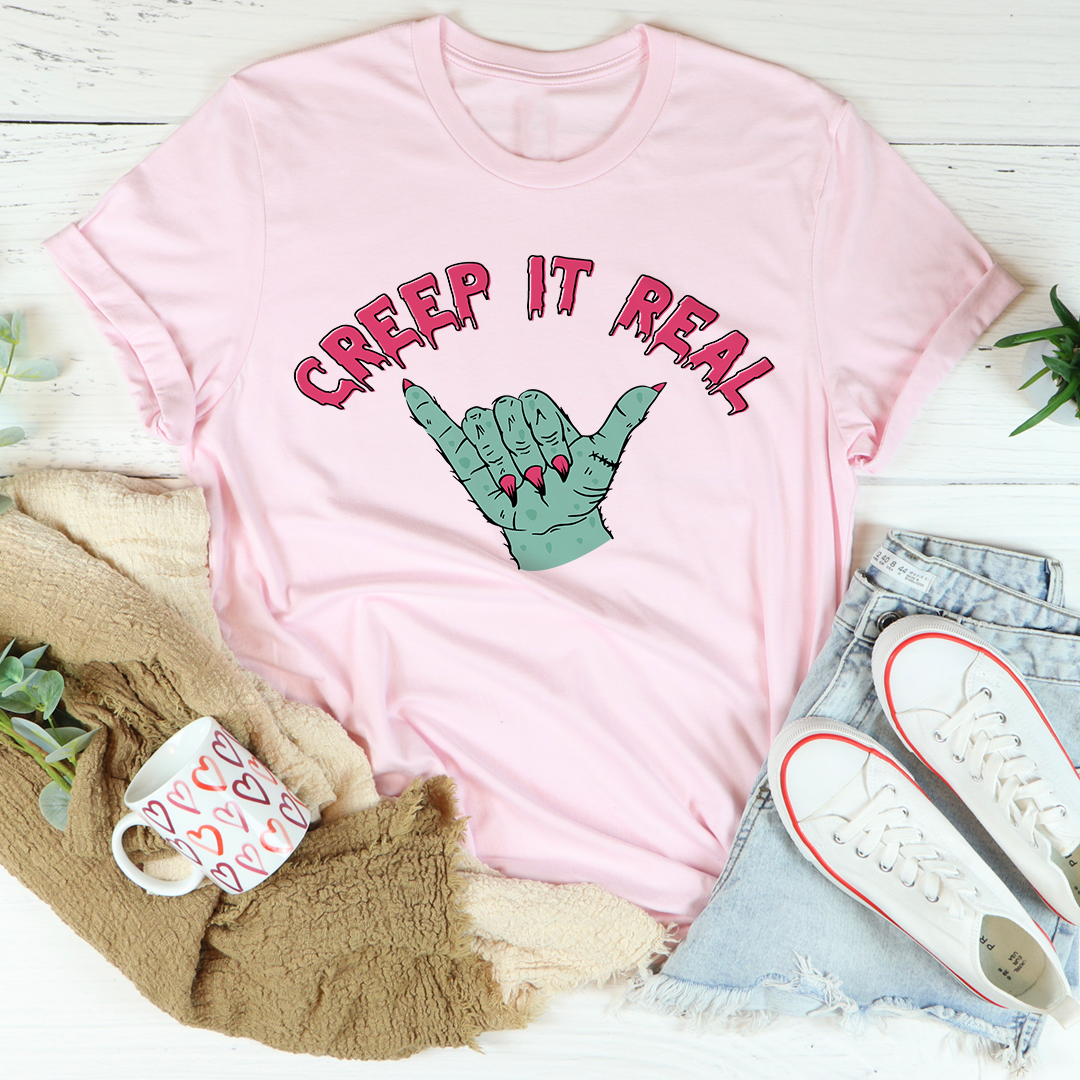 Pink crew-neck short-sleeve T-shirt with “Creep It Real” lettering and green crab graphic