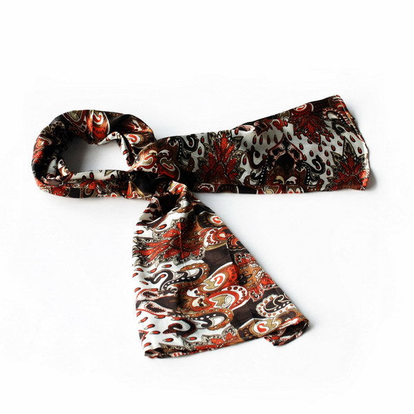 Paisley silk scarf in dark brown with red and cream motifs, neatly folded