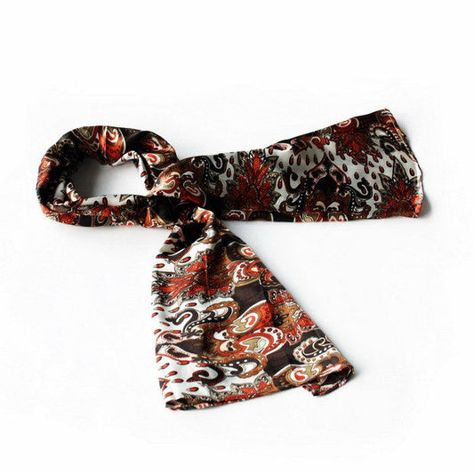 Paisley silk scarf in dark brown with red and cream motifs, neatly folded