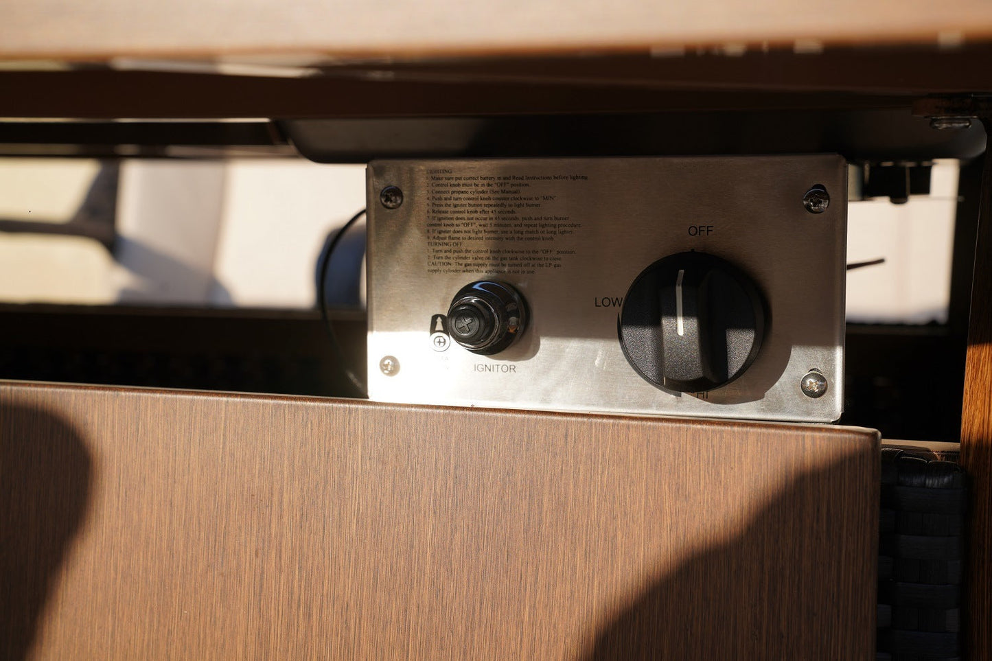 Gas firepit control panel with knob and settings dial on stainless steel