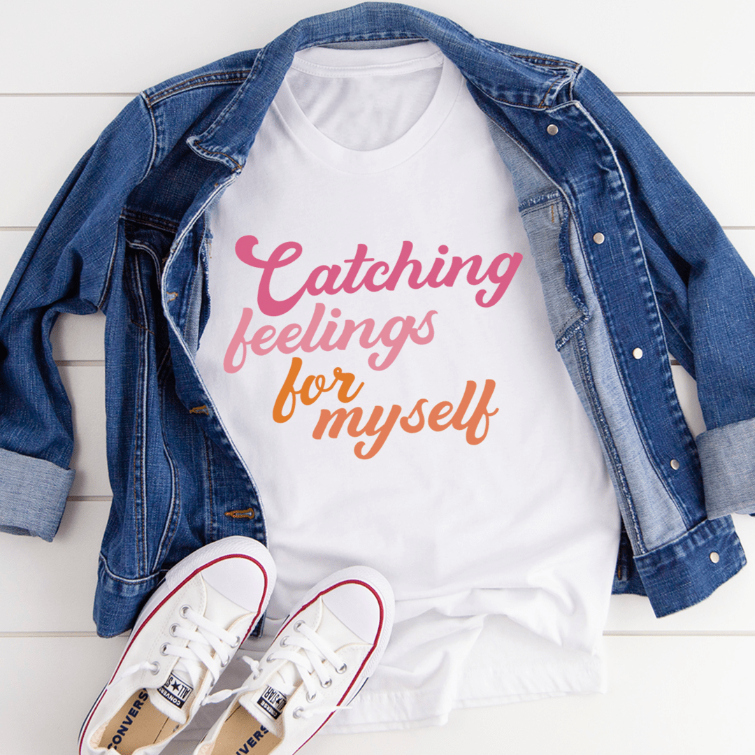 White crew-neck t-shirt with "Catching feelings for myself" graphic.