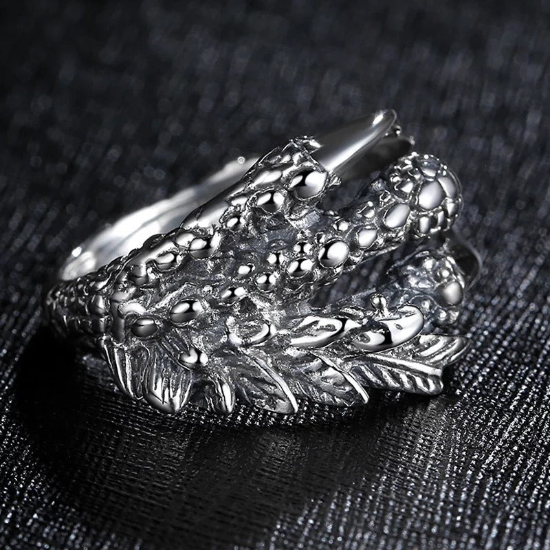Silver dragon claw ring close-up, textured scales and raised claws on open band