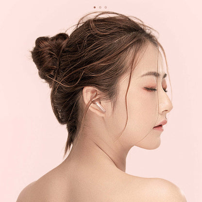 Woman wearing a pearl pink wireless earbud in her ear