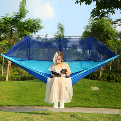 Two-person hammock with mosquito net, blue and teal fabric, with person nearby