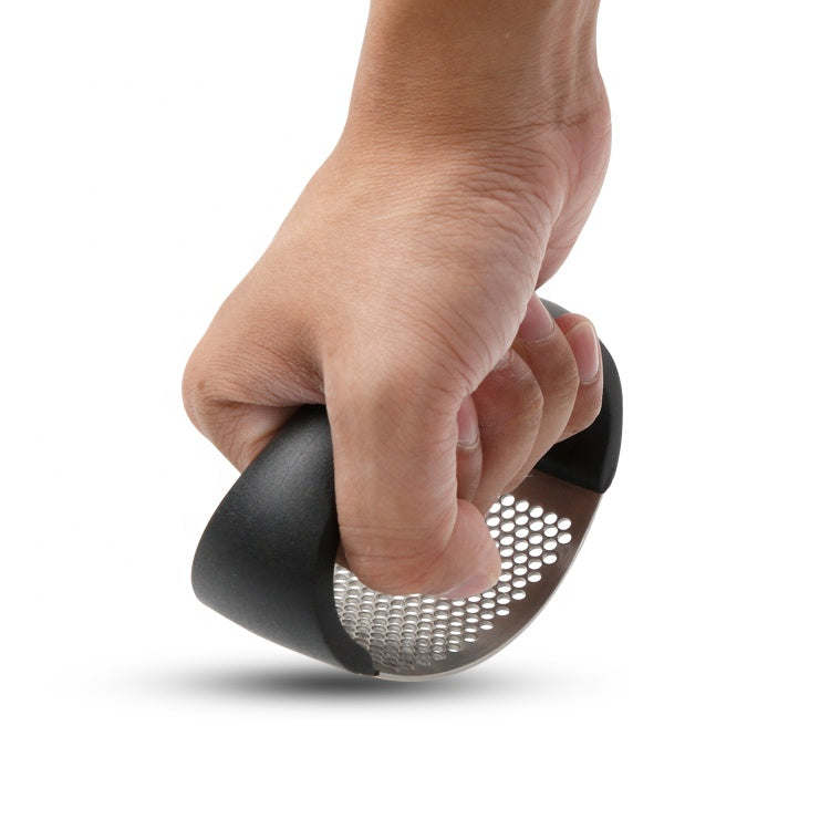 Hand squeezing an arc-shaped garlic press with black handle and perforated stainless plate