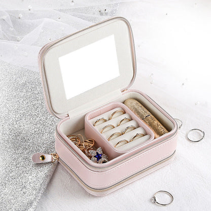 Pink jewelry organizer case with open lid, mirror panel, and ring compartments