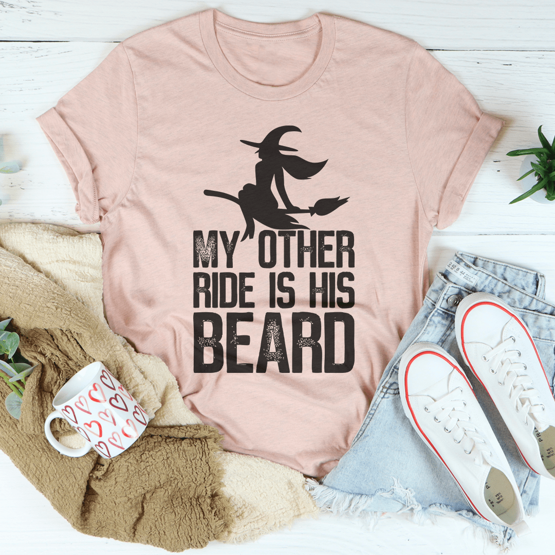 Light pink crewneck T-shirt with bearded rider silhouette and "MY OTHER RIDE IS HIS BEARD" text