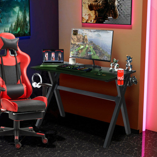 Black gaming desk with monitor, keyboard, and mouse on built-in mouse pad