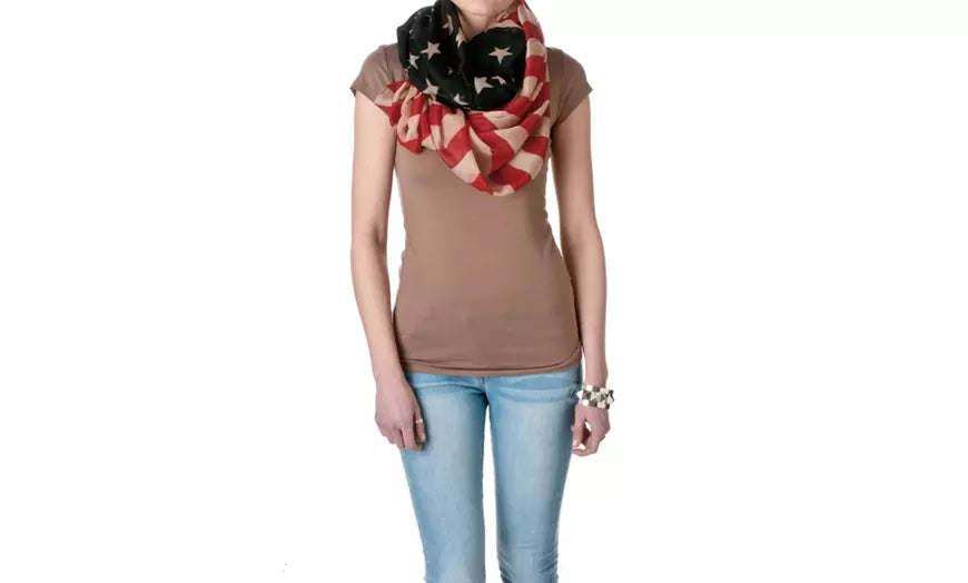 Infinity scarf worn by model, black with red and cream stars and striped bands, looped