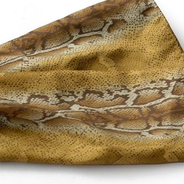 Close-up of gold and brown snake-print scarf fabric with spotted texture