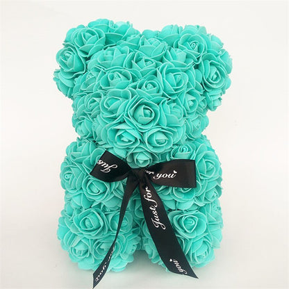 Turquoise rose teddy bear with layered rose petals and a black ribbon bow