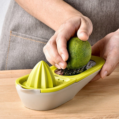 Green citrus juicer grater with cone reamer; hands squeezing a whole fruit
