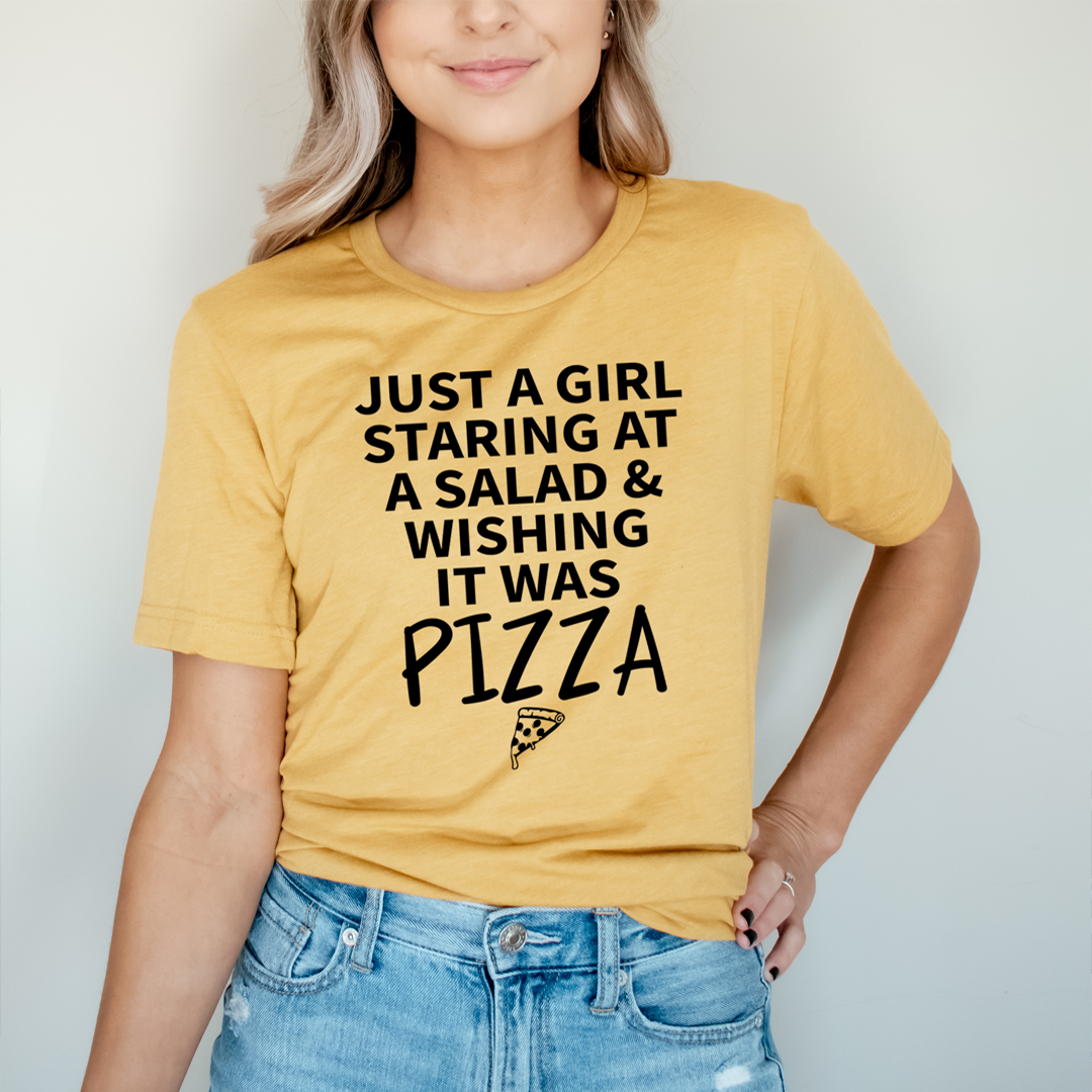 Mustard yellow women's graphic t-shirt with bold 'JUST A GIRL' and 'IT WAS PIZZA' text