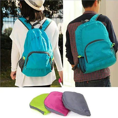 Turquoise folding backpack with front zip pocket and adjustable shoulder straps.