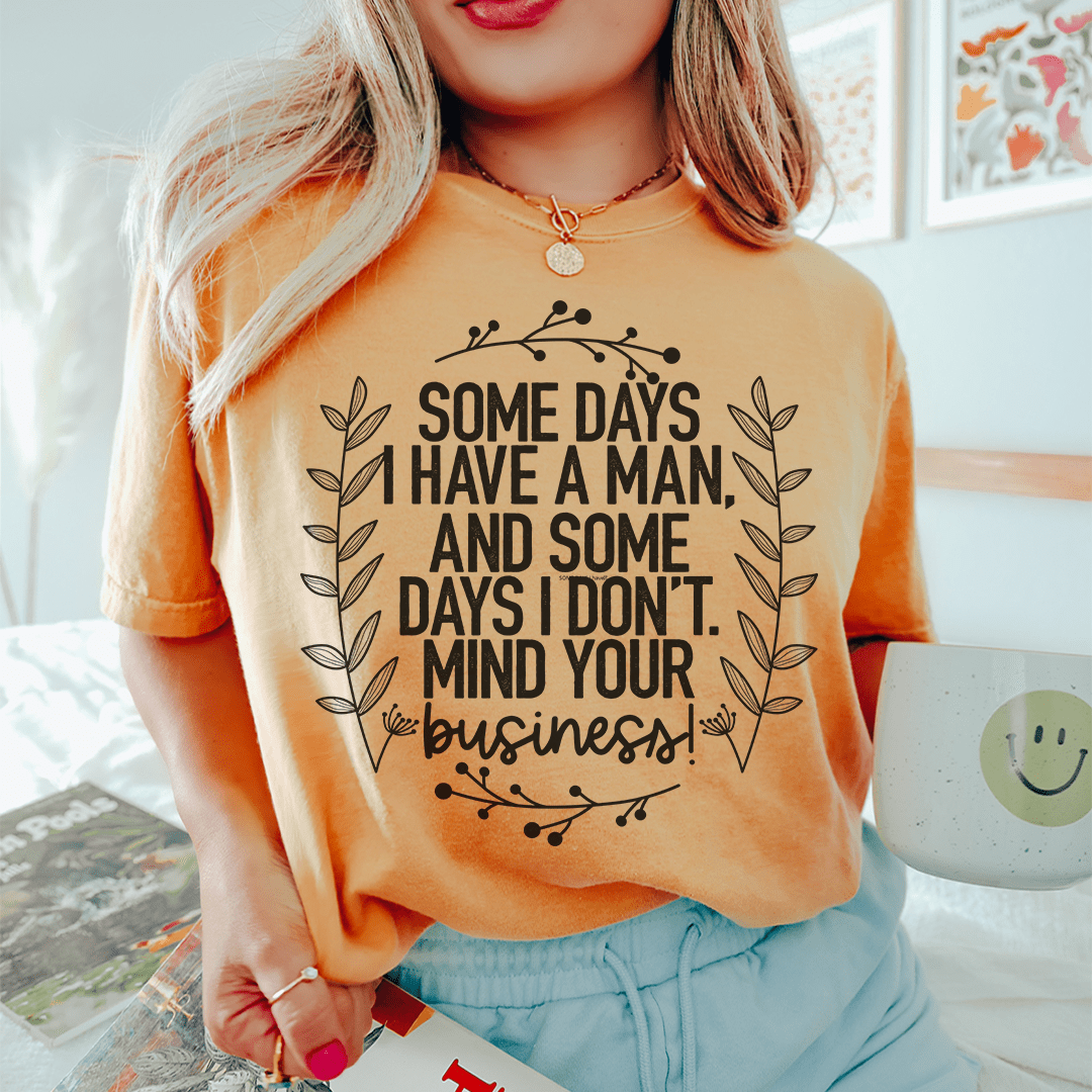 Orange crewneck T-shirt with centered black floral slogan graphic