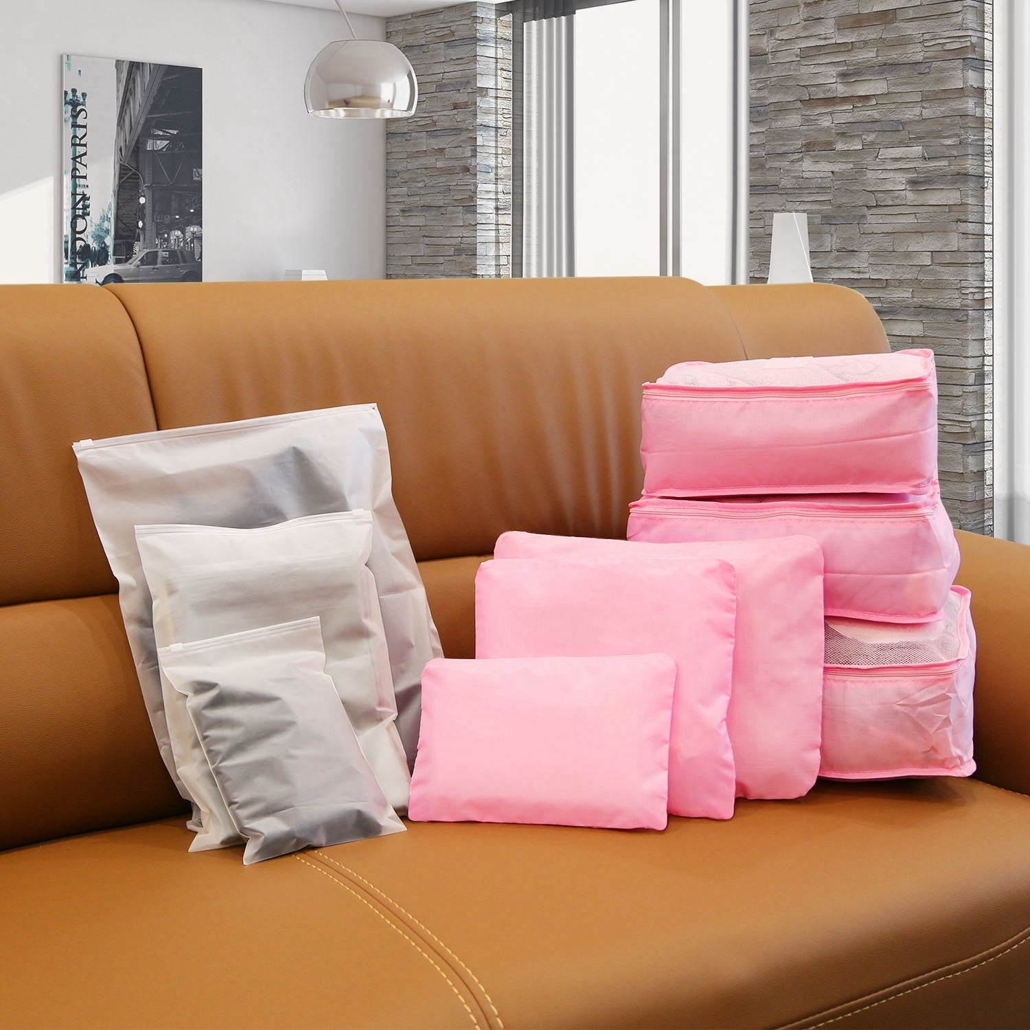 Set of pink and white packing cubes with zip tops, stacked on a sofa