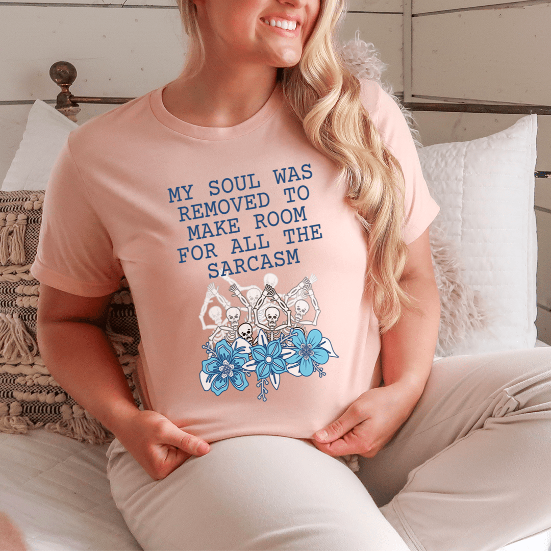 Heather Prism Peach T-shirt with blue text and floral cartoon graphic on front