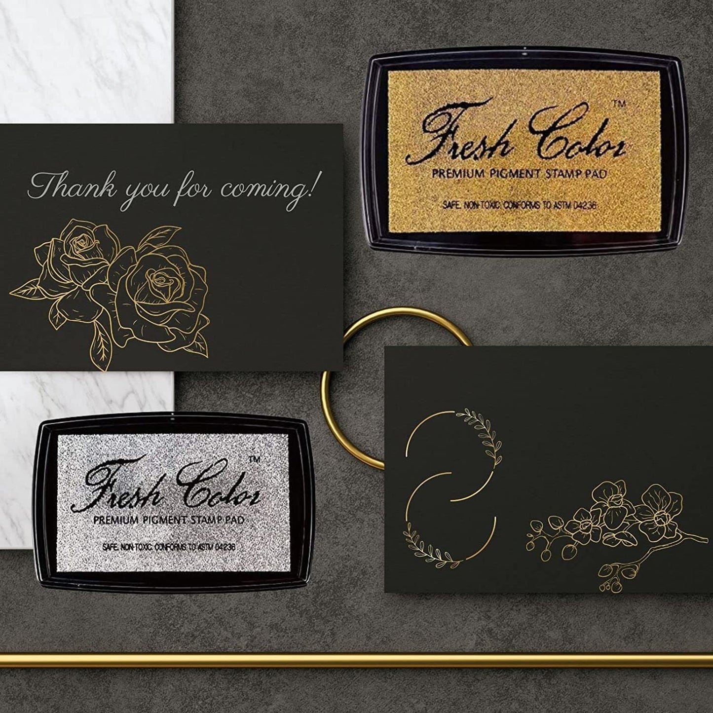 Gold and silver stamp pads with thank-you message cards on dark background.