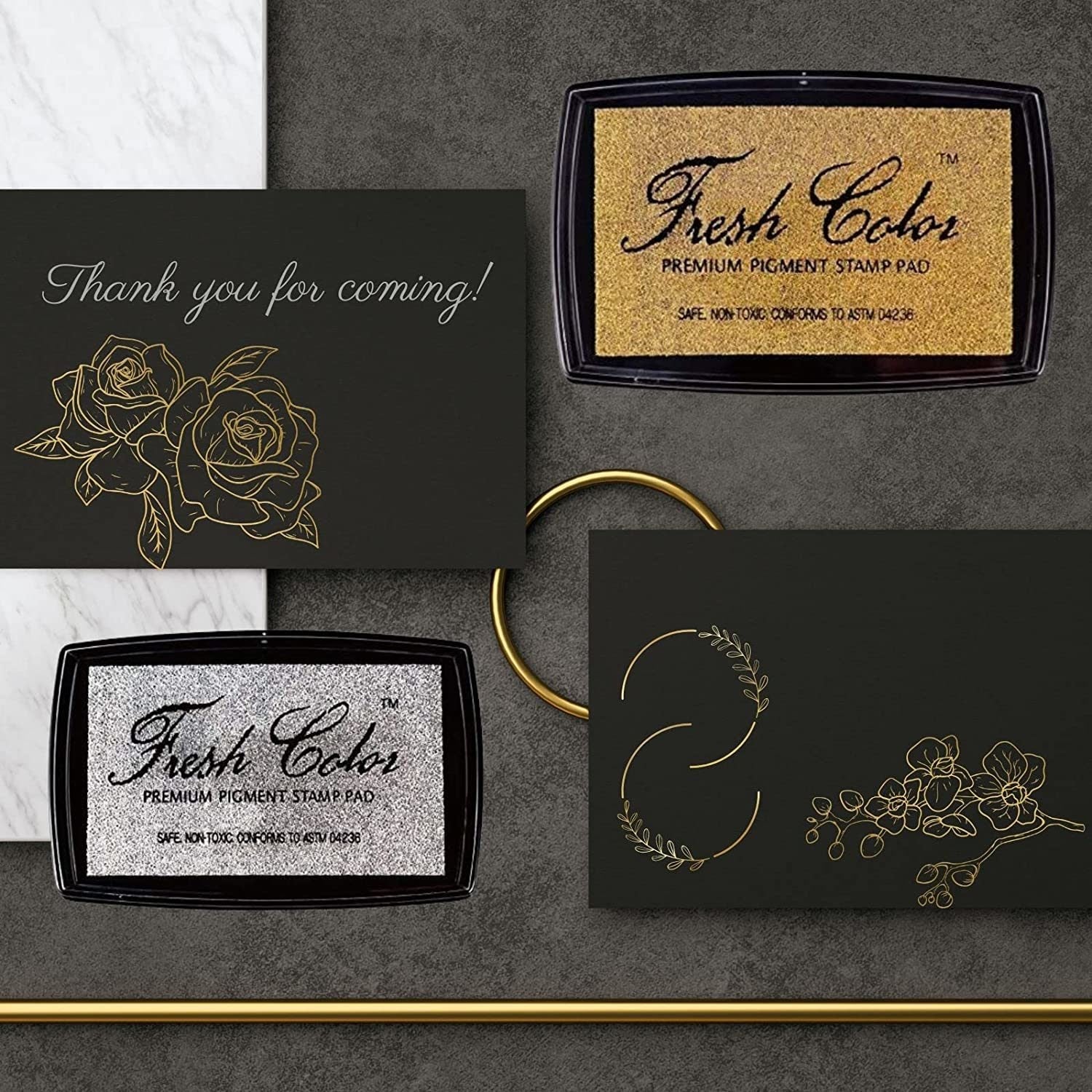 Gold and silver stamp pads with thank-you message cards on dark background.