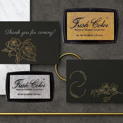 Gold and silver stamp pads with thank-you message cards on dark background.