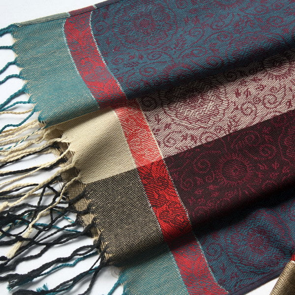Close-up pashmina fabric with teal and burgundy border, decorative weave, tassel fringe