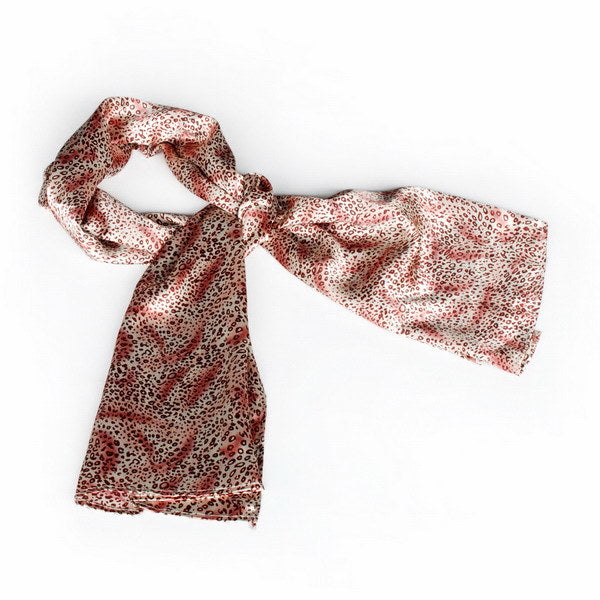 Leopard print silk scarf in warm pink, draped with long ends