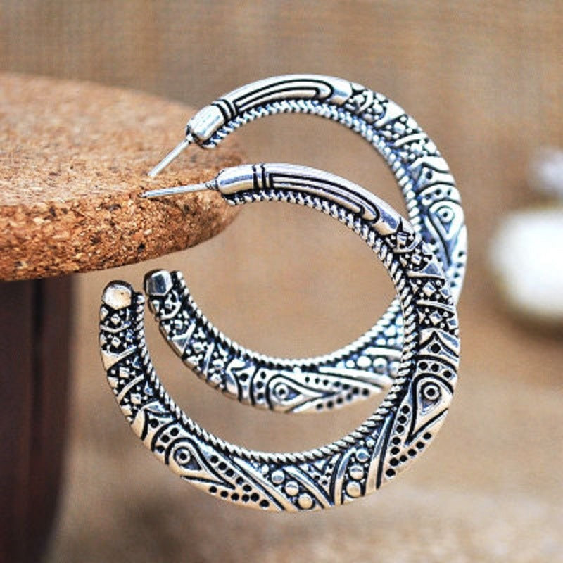 Silver-tone stud hoop earrings with ornate engraved crescent design and stud posts