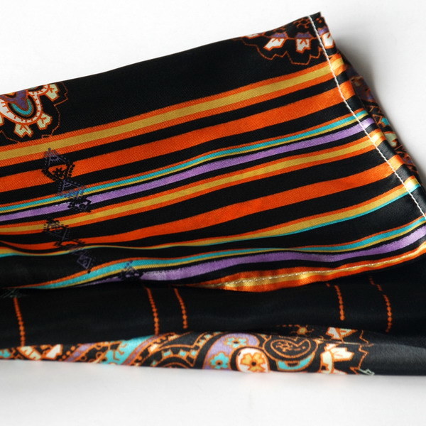 Silk scarf close-up: dark horizontal stripes with paisley motifs