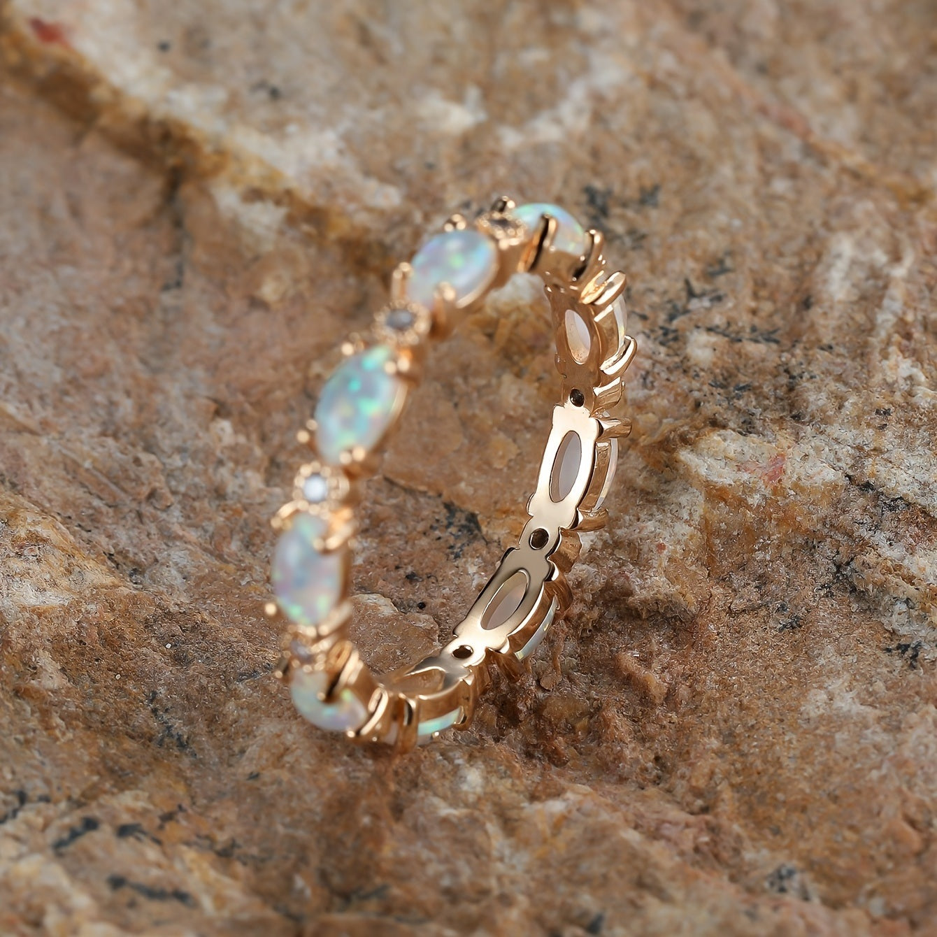 Gold-tone ring with three opal-style oval stones and cutout border detail