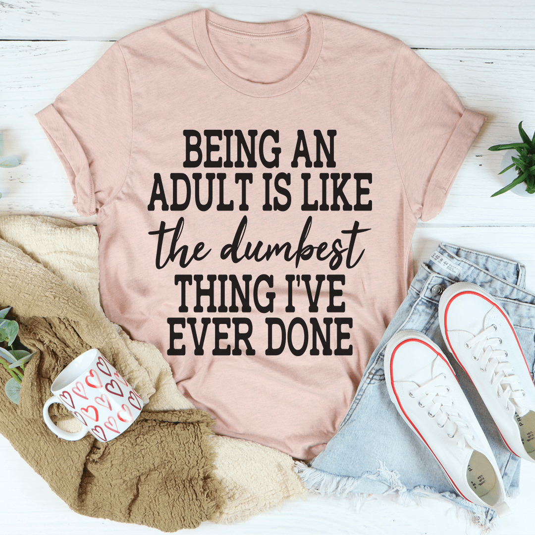 Mauve graphic T-shirt with black text: “BEING AN ADULT IS LIKE…”